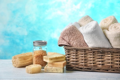 Basket with clean towels, soap and sea salt on table