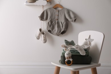 Photo of Cute children's clothes and shoes in room. Space for text
