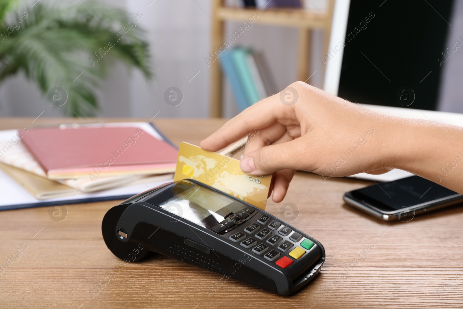 Photo of Woman using terminal for credit card payment at table