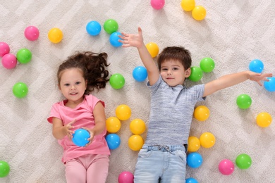 Cute little children with toys on floor indoors, top view