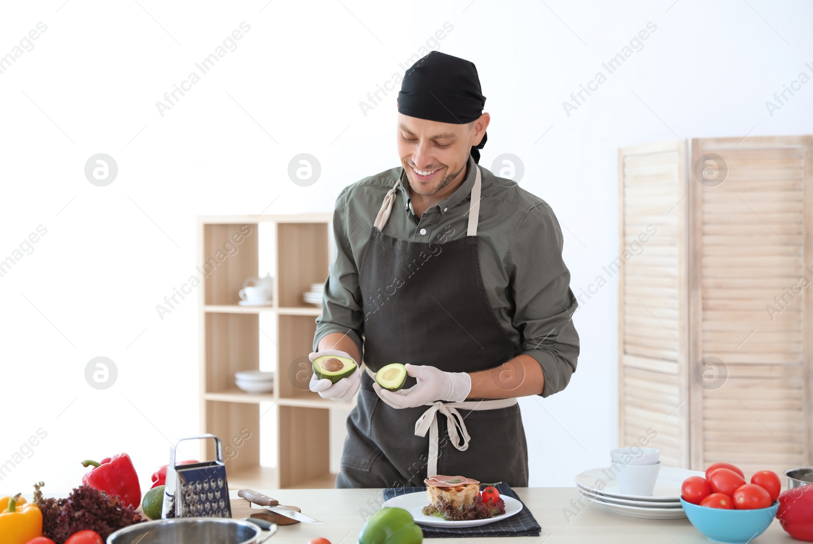 Photo of Professional chef preparing dish on table in kitchen