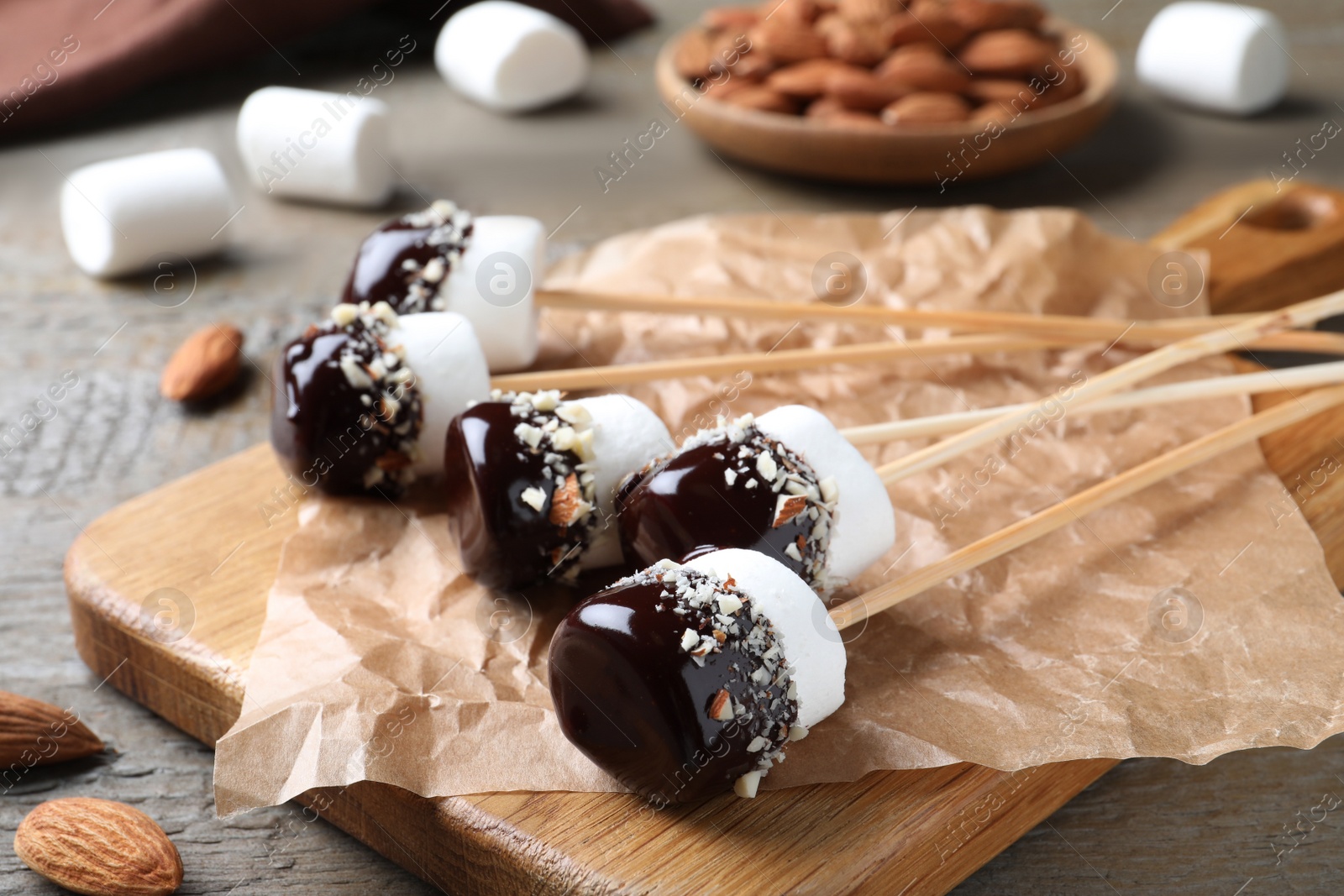 Photo of Delicious marshmallows covered with chocolate on wooden table