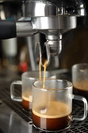Making fresh aromatic espresso using professional coffee machine