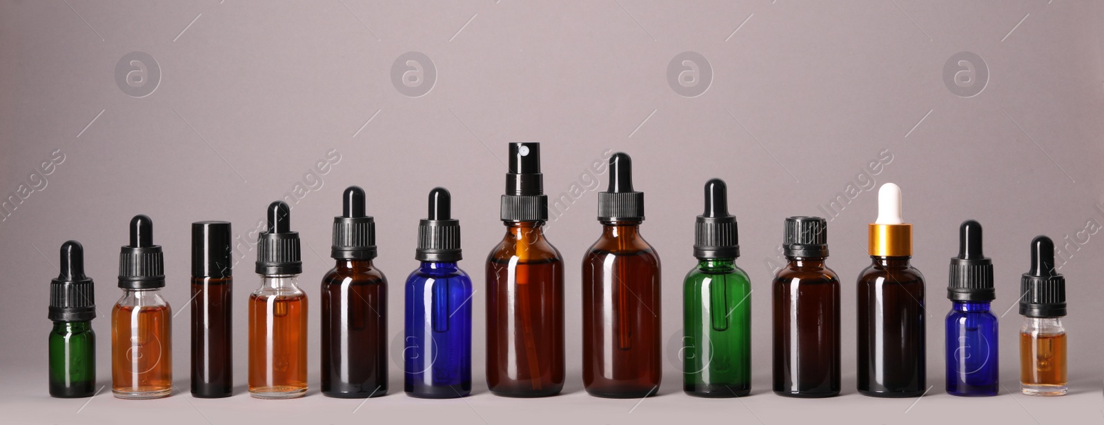 Photo of Cosmetic bottles of essential oils on color background