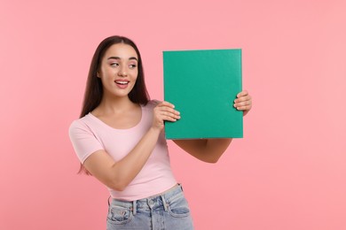 Woman with green folder on pink background