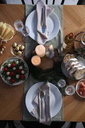 Christmas table setting with festive decor and dishware, top view