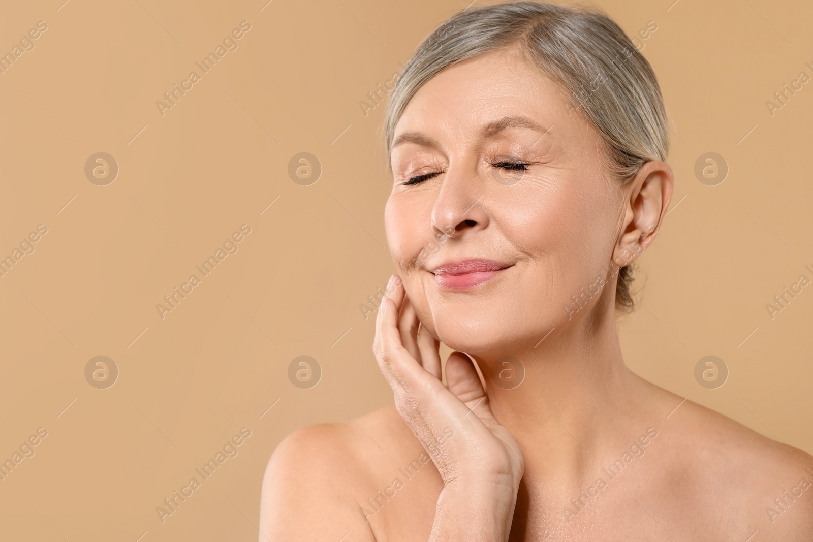 Photo of Beautiful mature woman with healthy skin on beige background, space for text