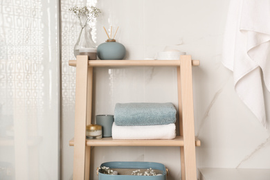 Shelving unit with clean towels in bathroom interior