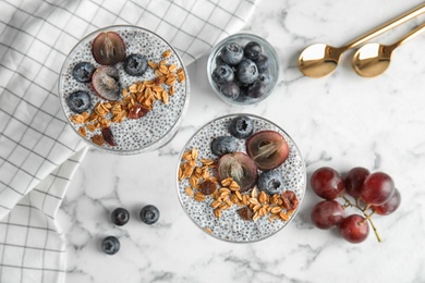 Photo of Tasty chia seed pudding with granola served on table, flat lay