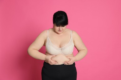 Photo of Obese woman on pink background. Weight loss surgery