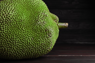 Photo of Fresh exotic jackfruit on black wooden table, closeup