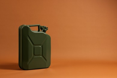 Photo of New khaki metal canister on brown background. Space for text