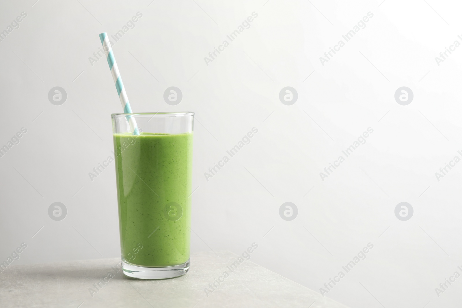 Photo of Tasty kale smoothie on light grey marble table, space for text