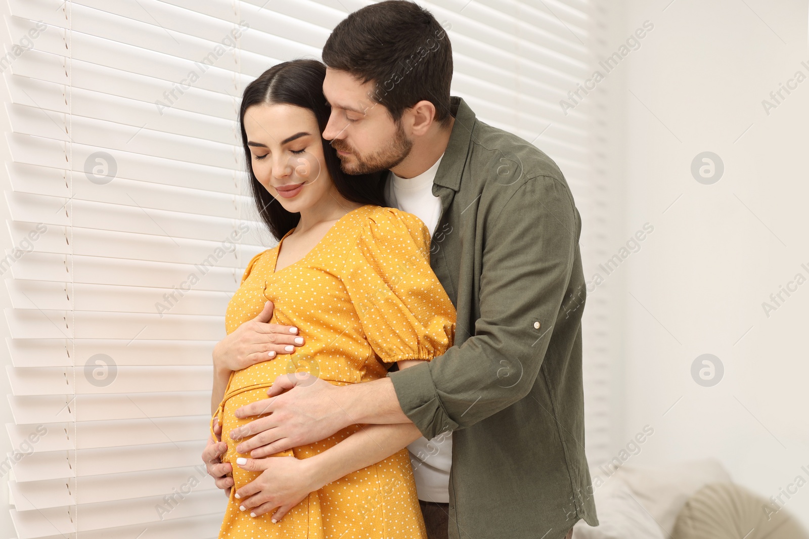 Photo of Pregnant young woman with her husband indoors
