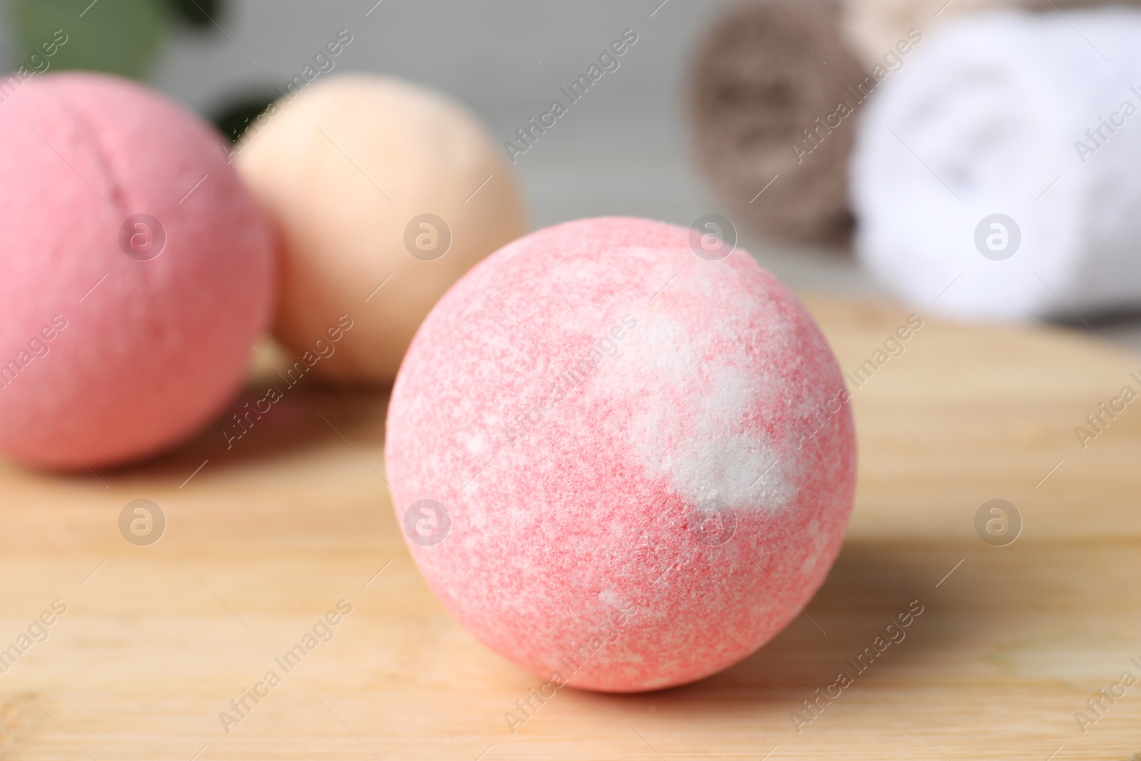 Photo of Beautiful aromatic bath bomb on wooden board, closeup