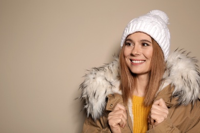 Photo of Young woman wearing warm clothes on color background, space for text. Ready for winter vacation