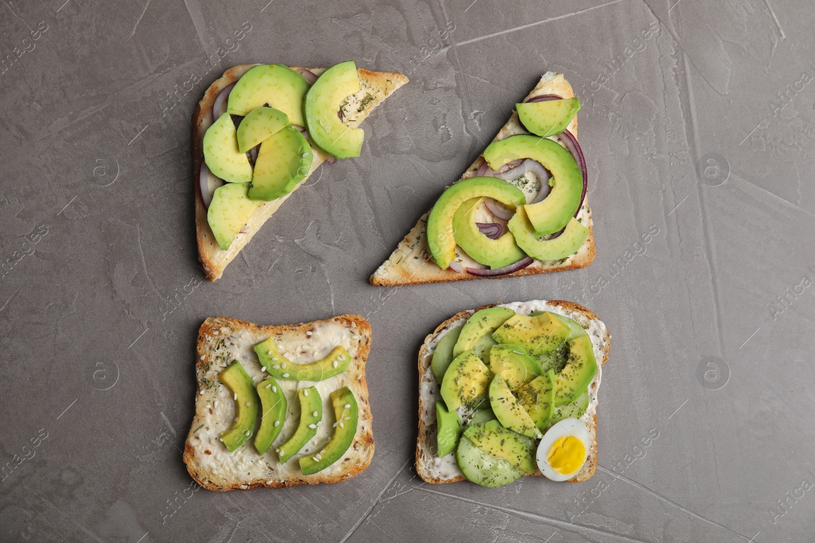 Photo of Tasty avocado toasts on grey table, flat lay