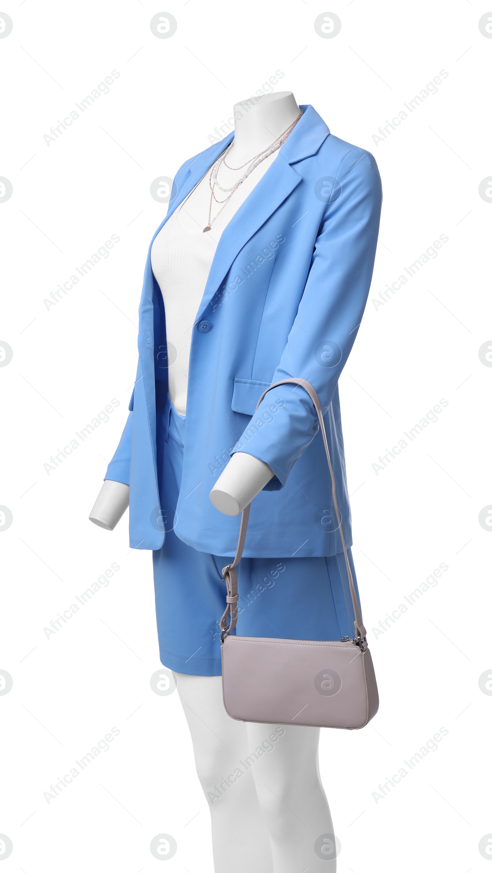 Photo of Female mannequin dressed in light blue suit and top with accessories isolated on white. Stylish outfit