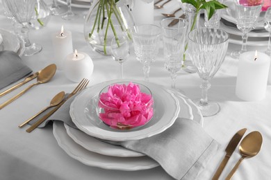 Stylish table setting with beautiful peony in dining room