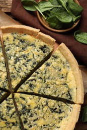 Cut delicious spinach pie on table, top view