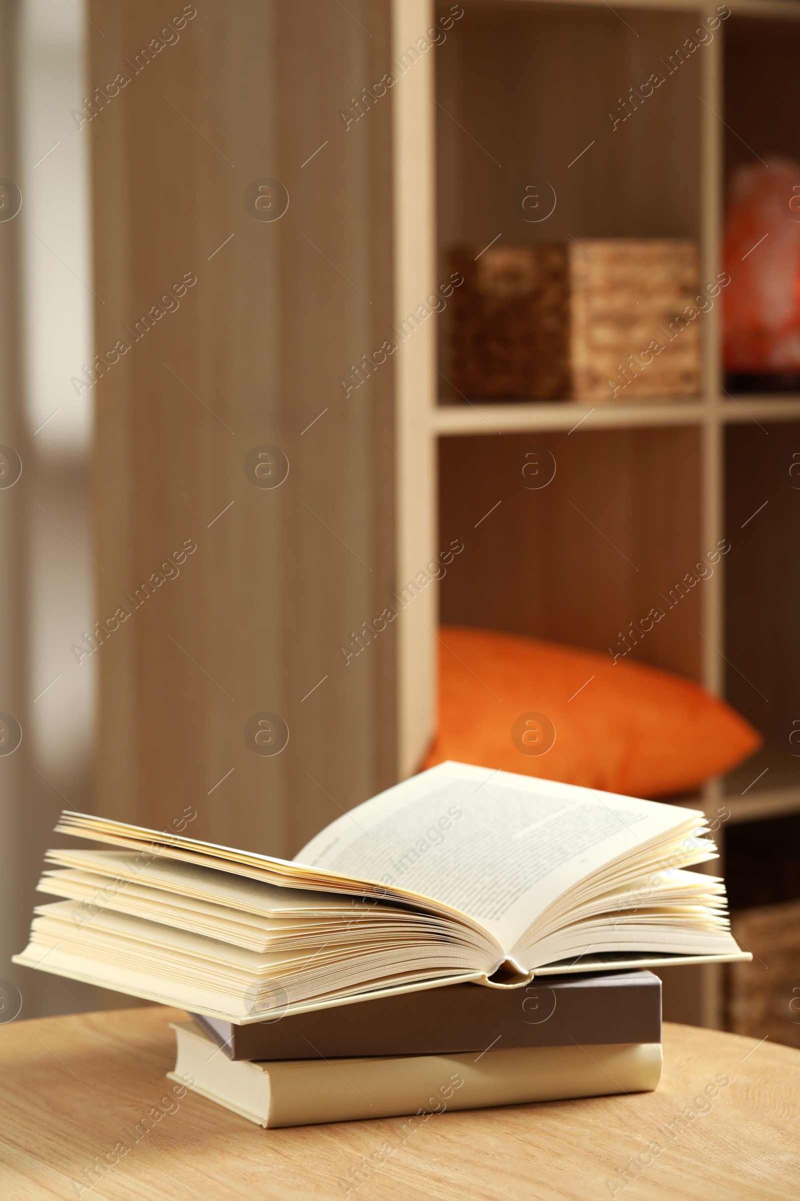 Photo of Stack of different books on wooden table indoors, space for text