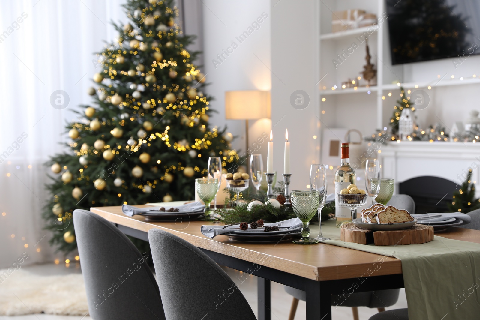 Photo of Christmas table setting with festive decor and dishware in living room