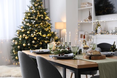 Christmas table setting with festive decor and dishware in living room