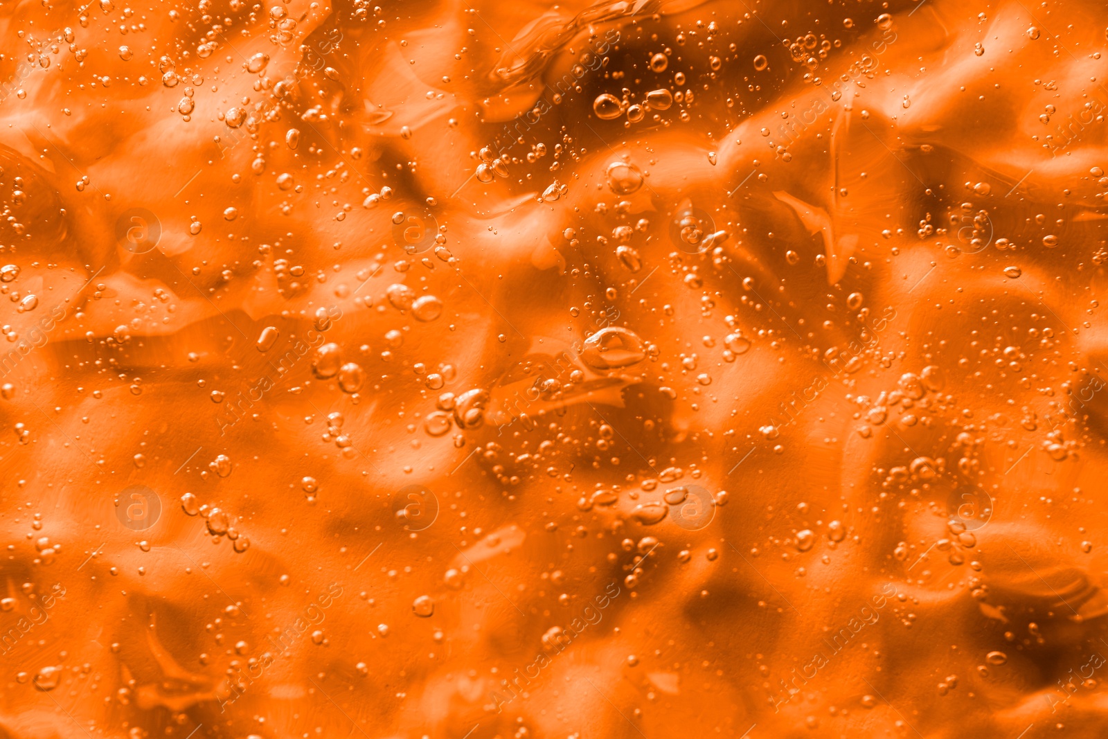 Image of Texture of transparent cosmetic gel as background, closeup. Toned in orange