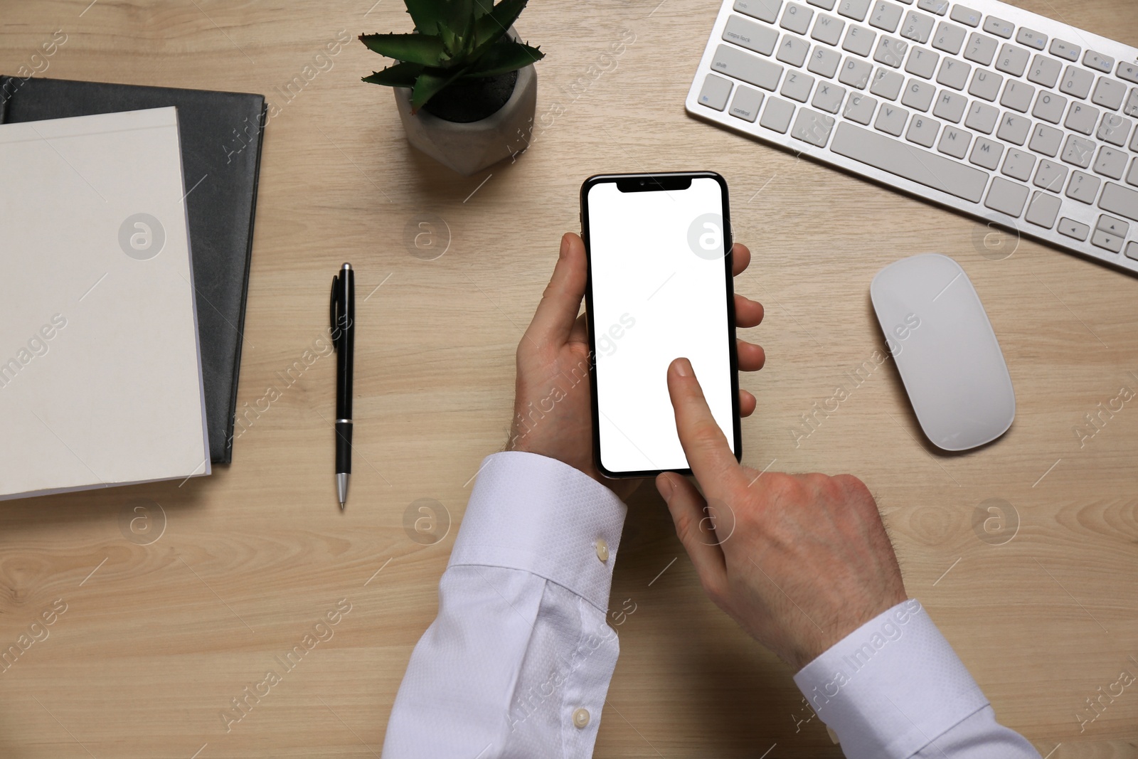 Photo of Man using smartphone at wooden table, top view