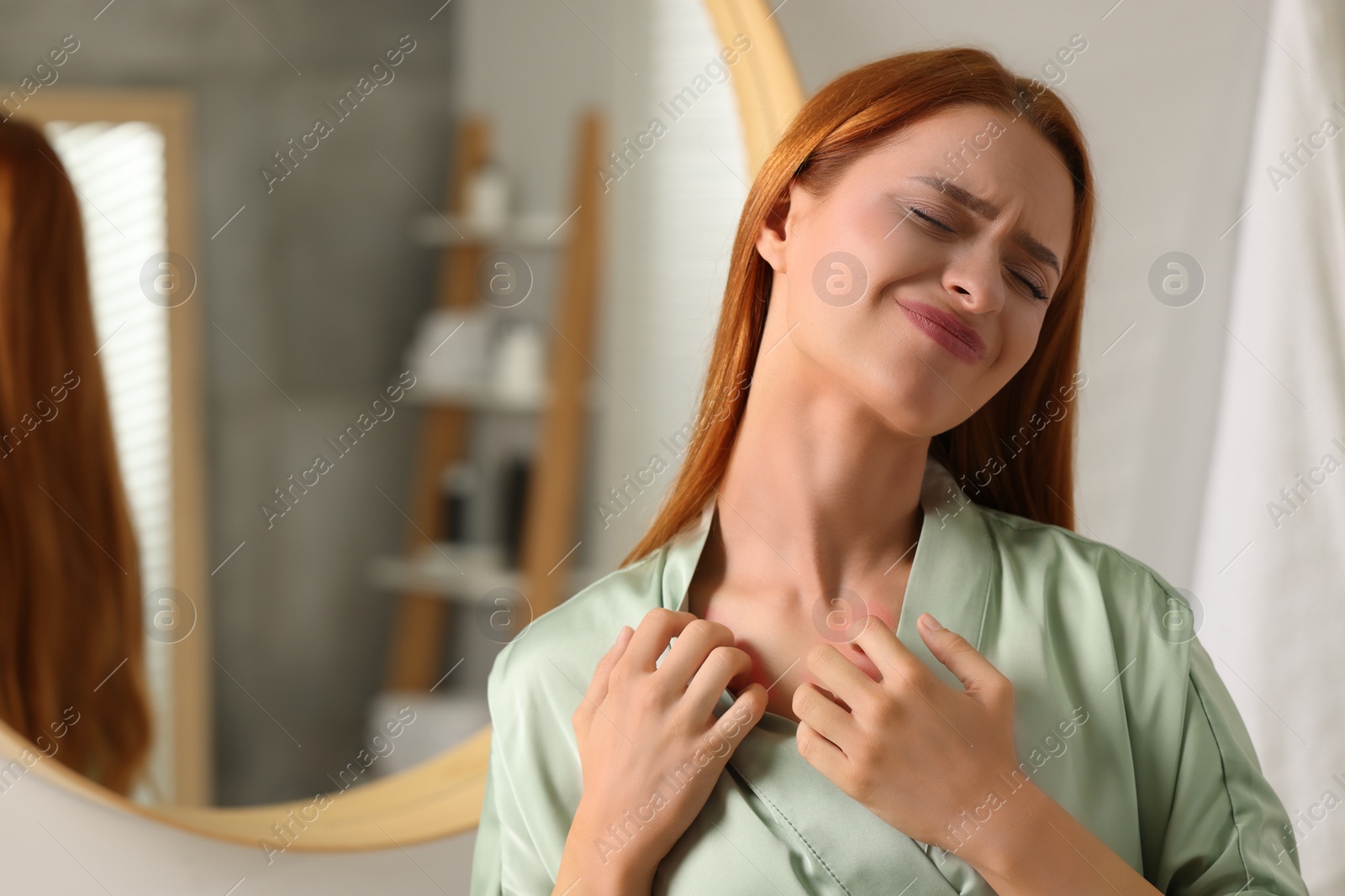 Photo of Suffering from allergy. Young woman scratching her neck in bathroom, space for text