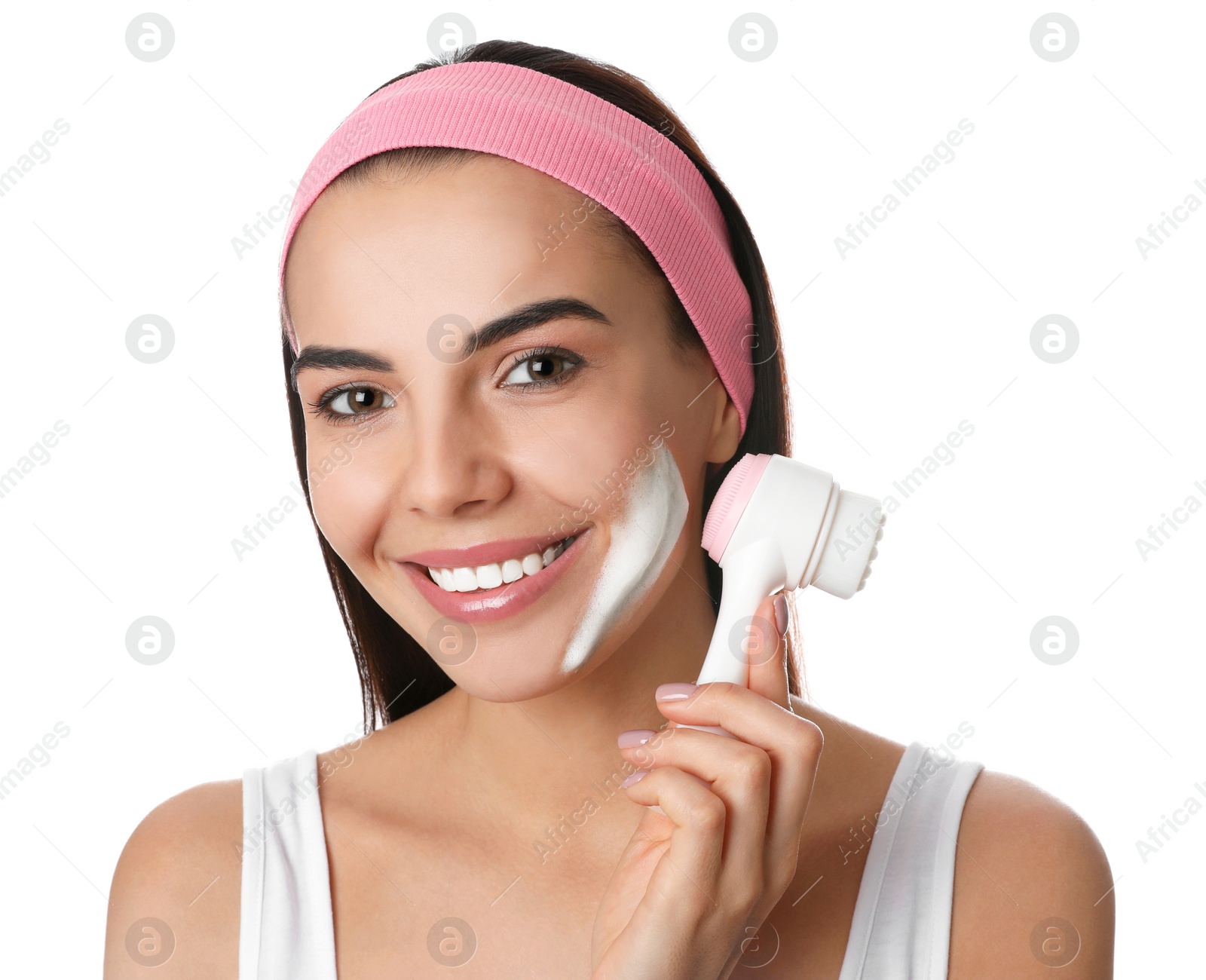 Photo of Young woman using facial cleansing brush on white background. Washing accessory