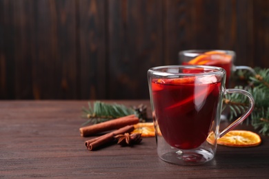 Photo of Delicious mulled wine on wooden table, space for text