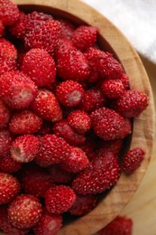 Photo of Fresh wild strawberries in bowl on table, top view