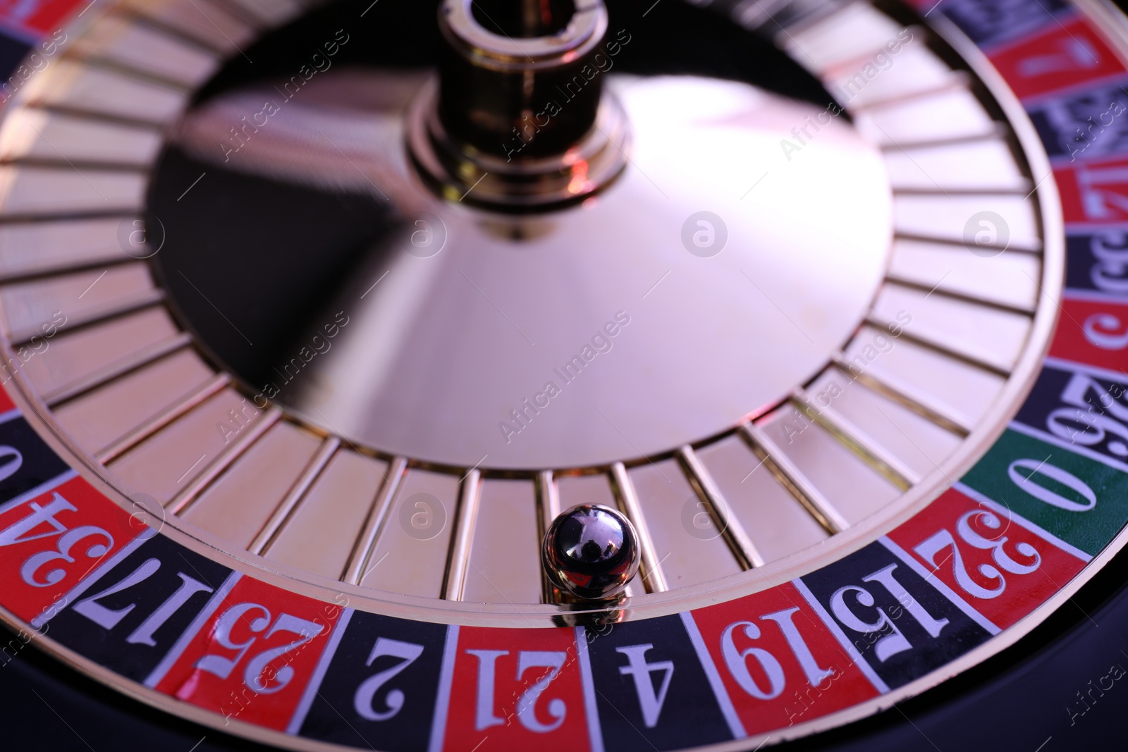 Photo of Roulette wheel with ball, closeup. Casino game