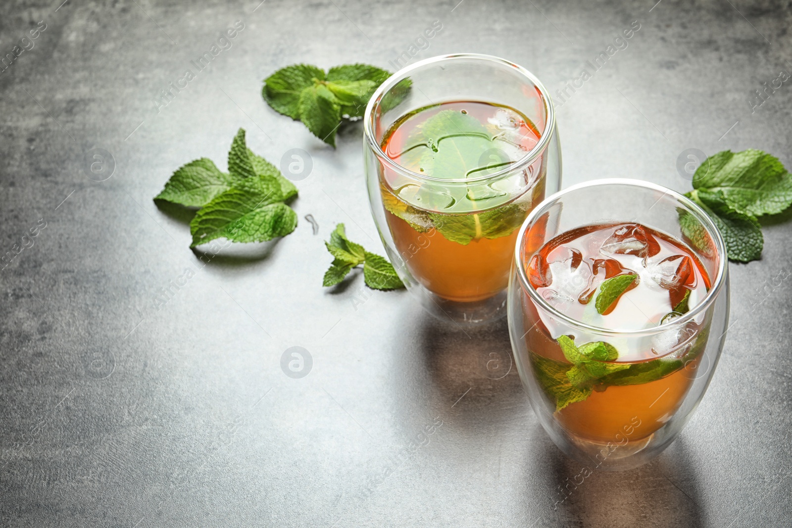 Photo of Glasses with aromatic mint tea on table