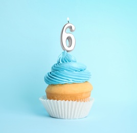 Photo of Birthday cupcake with number six candle on blue background