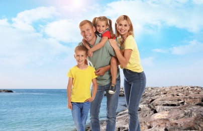 Image of Happy family on rocky beach near sea. Summer vacation