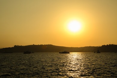 Photo of Picturesque view of calm sea with yachts and boats at sunset