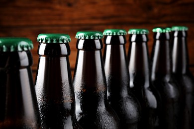 Photo of Many bottles of beer on wooden background, closeup