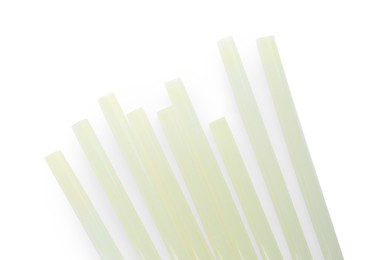 Photo of Many glue sticks for gun on white background, top view