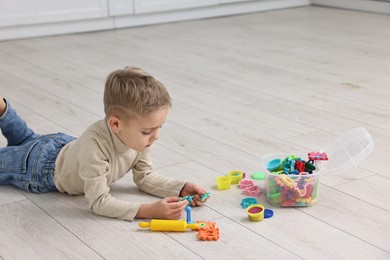 Photo of Cute little boy playing on warm floor indoors, space for text. Heating system