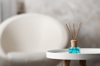 Photo of Reed air freshener on white table indoors, space for text