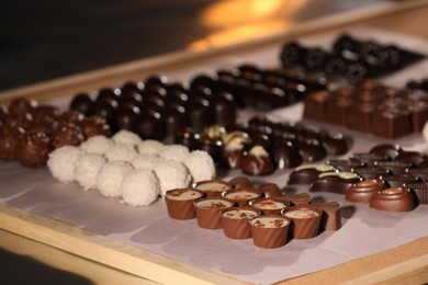 Many delicious chocolate candies on table, closeup. Production line