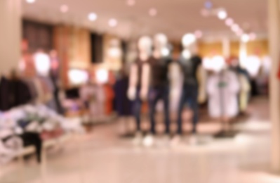 Photo of Blurred view of modern store with different clothes