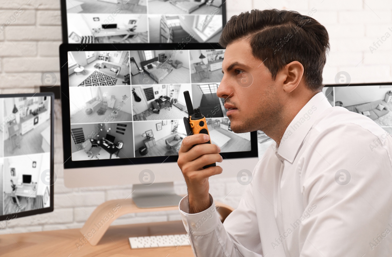 Photo of Male security guard with portable transmitter at workplace