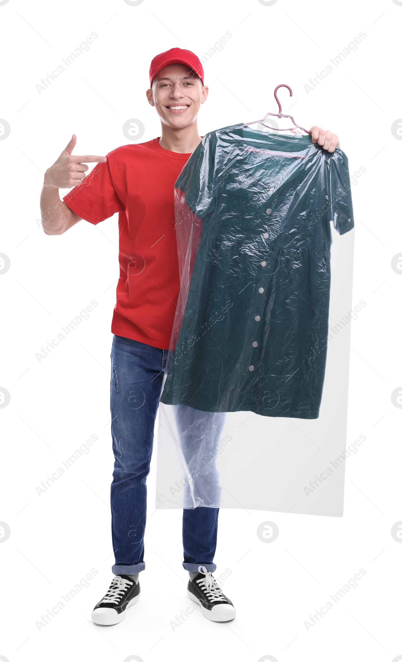 Photo of Dry-cleaning delivery. Happy courier holding dress in plastic bag on white background
