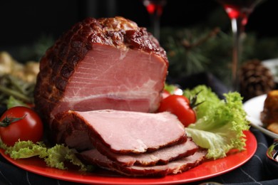 Photo of Plate with delicious ham, lettuce and tomatoes on black wooden table, closeup