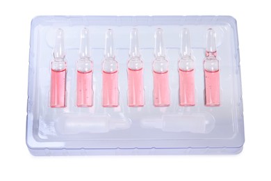 Glass ampoules with pharmaceutical product in tray on white background