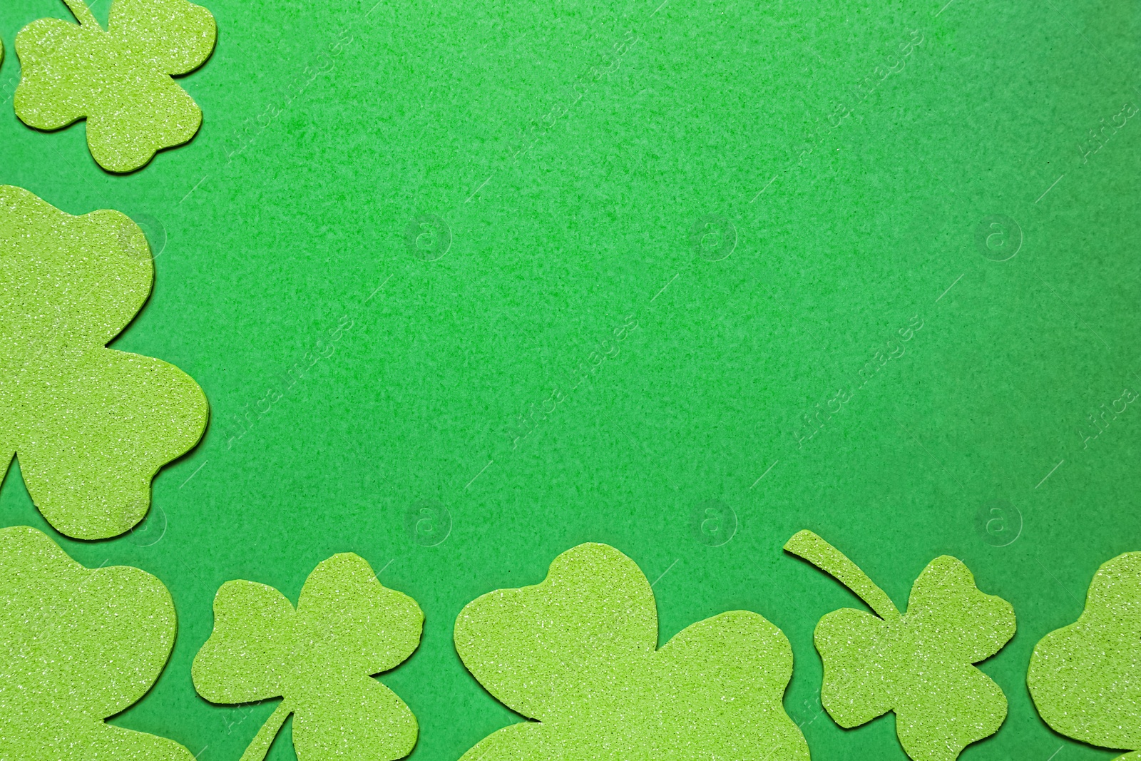 Photo of Flat lay composition with clover leaves on light green background, space for text. St. Patrick's Day celebration