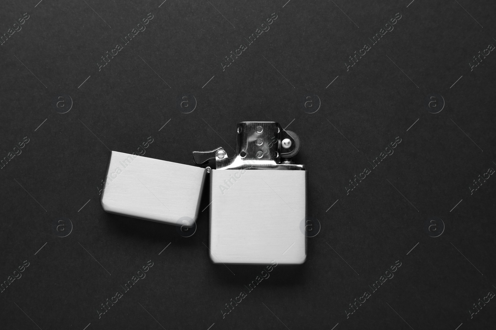 Photo of Gray metallic cigarette lighter on black background, top view